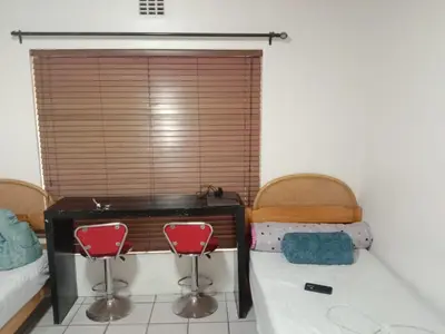 a bedroom with a desk and two chairs and a window at Cape Town 5 bedroom house Belhar in Cape Town