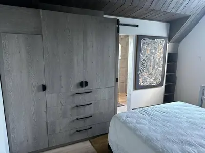 a bedroom with a large wooden dresser and a bed at Lemon House Modern duplex by UCT in Cape Town