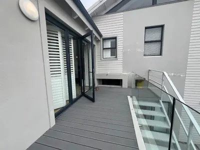 a house with a glass staircase leading to a balcony at Sunset Starfish Apartment in Cape Town