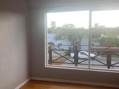 an empty room with a large window and a balcony at Gizelle in Cape Town