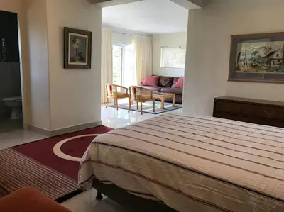 a bedroom with a bed and a living room at Tolbos Garden in Cape Town
