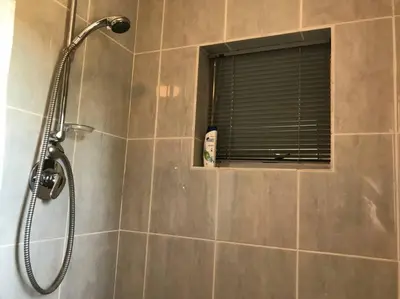 a shower with a window in a bathroom at Tolbos Garden in Cape Town
