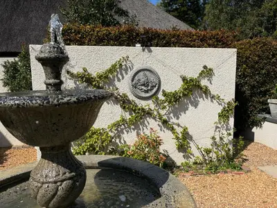 a stone fountain in a yard with a statue at In the Vine Country Manor Guesthouse in Stellenbosch