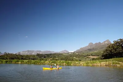 two people in a yellow kayak on a lake at In the Vine Country Manor Guesthouse in Stellenbosch