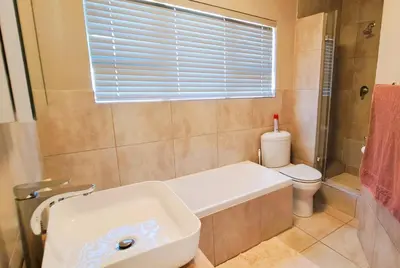 a bathroom with a tub and a toilet and a sink at Cap d Azur beachfront apartment in Strand