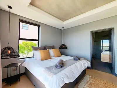 a bedroom with a large white bed and a window at Drift Sunset Beach House in Sunset Beach