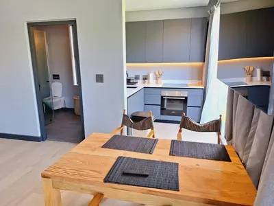 a small kitchen with a wooden table and chairs at Drift Sunset Beach House in Sunset Beach