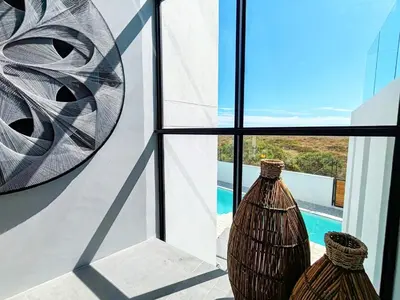 two vases sitting on a window sill looking out at a pool at Drift Sunset Beach House in Sunset Beach