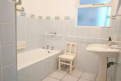 a bathroom with a bath tub and a sink at Shonalanga (The setting sun) in Hermanus