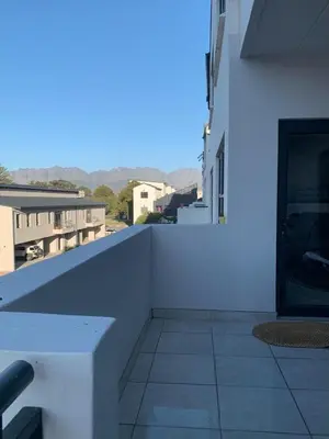 a white balcony with a bench on a building at Luxury Beach Apartment in Cape Town