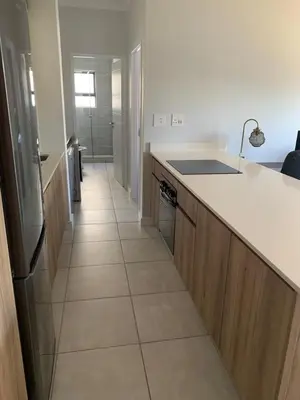 a kitchen with a counter and a tile floor at Luxury Beach Apartment in Cape Town