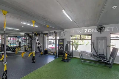 a gym with treadmills and machines in a room at Luxury Beach Apartment in Cape Town