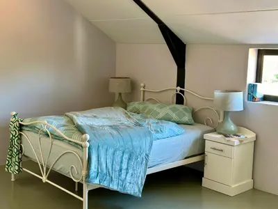 a bedroom with a bed with a blue comforter at World of Horses Stables in Stellenbosch