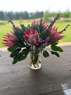 a vase with flowers in it on a table at World of Horses Stables in Stellenbosch