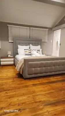 a large bed in a bedroom with wooden floors at Calmness in Claremont in Cape Town