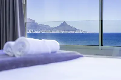 a bed with a window with a view of the ocean at Sea Spray B306 in Bloubergstrand