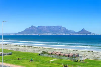 a view of the beach with mountains in the background at Sea Spray B306 in Bloubergstrand