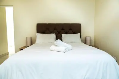 a large white bed with two towels on it at Sea Spray A308 in Bloubergstrand