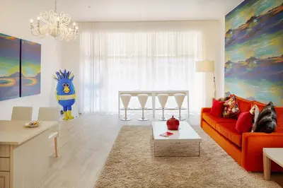 a living room with an orange couch and a table at First Group Cape Gordonia in Gordonʼs Bay