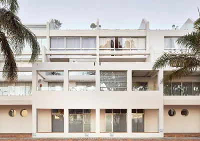 an image of a white building with palm trees at First Group Cape Gordonia in Gordonʼs Bay