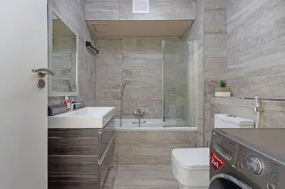 a bathroom with a toilet and a sink and a shower at Resort Style Penthouse - BackUp Power in Cape Town
