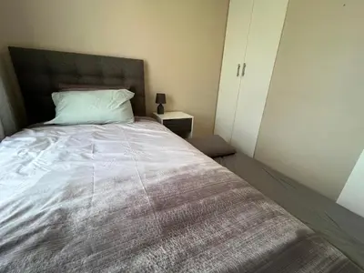 a bedroom with a large bed with a white comforter at #One6Eight in Hermanus