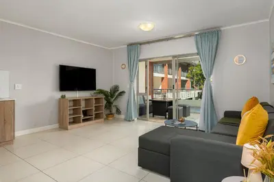 a living room with a couch and a tv at Mayfair 219 in Cape Town