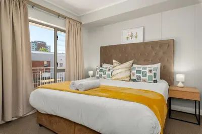 a bedroom with a large bed with a window at Mayfair 219 in Cape Town
