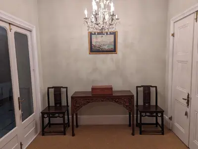 a room with a table and two chairs and a chandelier at La Montagne Observatory in Cape Town