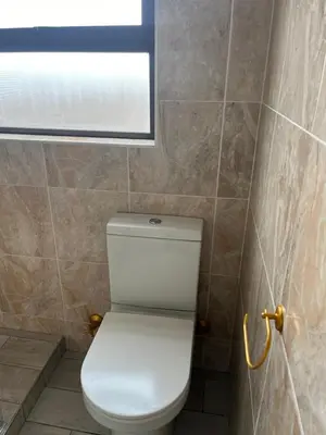a white toilet in a bathroom with a window at Top Floor Executive apartment in Cape Town