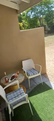 a patio with two chairs and a table and a table and chairs at Bellville Self Catering in Cape Town