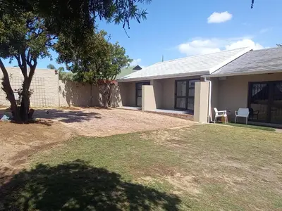 a house with a tree in front of a yard at Bellville Self Catering in Cape Town