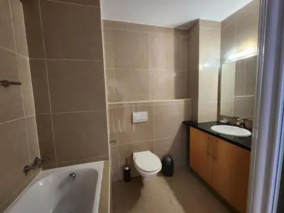 a bathroom with a toilet and a sink and a tub at Hibernian Towers 1203 in Strand