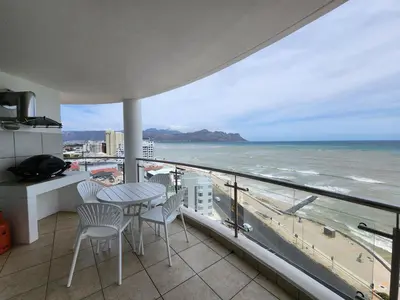 a balcony with a table and chairs and the ocean at Hibernian Towers 1203 in Strand