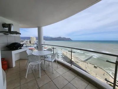a balcony with a table and chairs and the ocean at Hibernian Towers 1203 in Strand