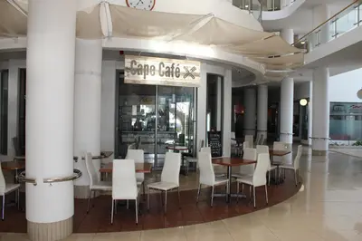 a dining room with white chairs and tables in a building at Hibernian Towers 1203 in Strand