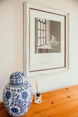 a blue and white vase on a table with a picture at Die Stal at Antioch in Franschhoek