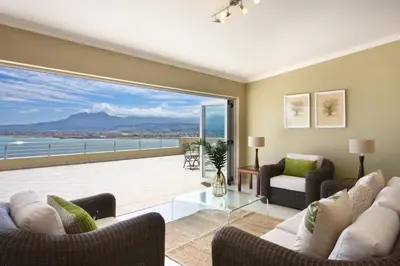 a living room with a view of the ocean at Bayview in Gordonʼs Bay