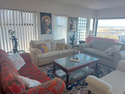 a living room with couches and a coffee table at The Waves of Schulphoek in Hermanus