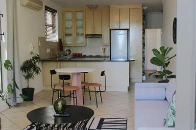 a kitchen and living room with a table and chairs at Contemporary Central Apartment by ARPA Hospitalities in Stellenbosch
