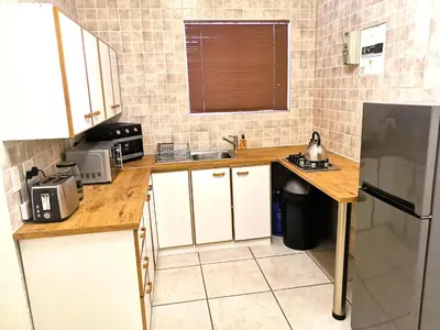 a small kitchen with a sink and a refrigerator at 28 on Ryneveld in Stellenbosch