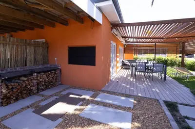 a patio with a television and a table and chairs at Garten Wohnung mit Pool, 2 Schlafzimmer in Cape Town