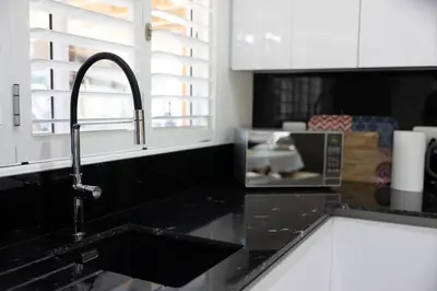 a kitchen counter with a sink and a faucet at Garten Wohnung mit Pool, 2 Schlafzimmer in Cape Town