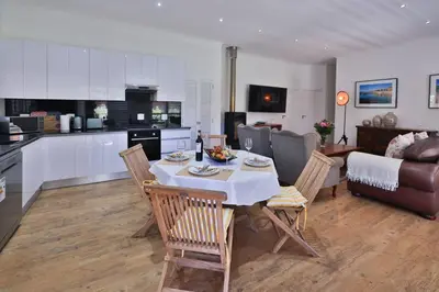 a kitchen and living room with a table and chairs at Garten Wohnung mit Pool, 2 Schlafzimmer in Cape Town