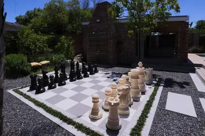a chessboard is sitting on a garden at Garten Wohnung mit Pool, 2 Schlafzimmer in Cape Town