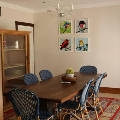 a dining room table with chairs and a chandelier at Kleinhof in Franschhoek