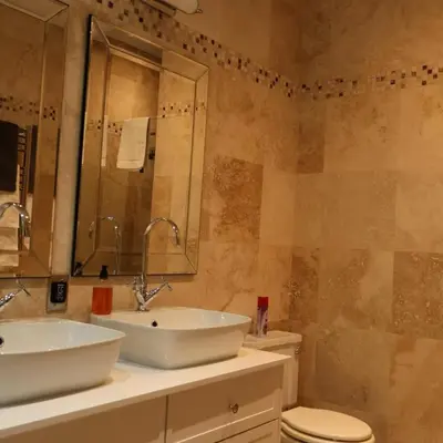 a bathroom with a sink and a toilet and a mirror at Kleinhof in Franschhoek