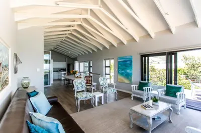 a living room with a couch and a table at Vue La Mer in Hermanus