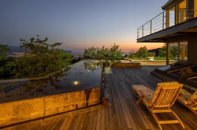 a deck with a chair and a pool of water at Spanish Farm Boutique Hotel & Villas in Somerset West