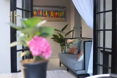 a living room with a blue couch and a plant at Trendy Cottage Hideaway in Cape Town